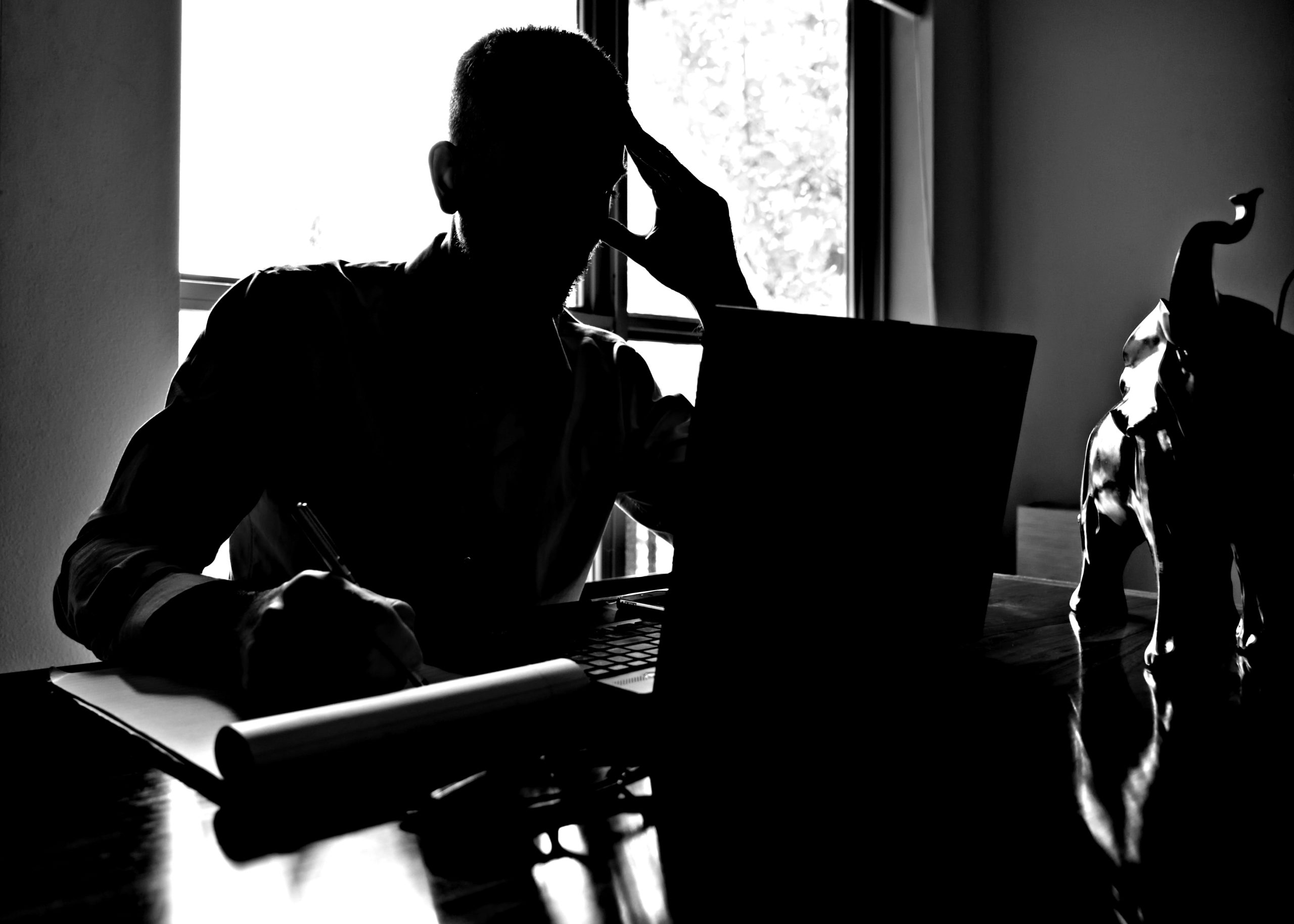 Mann am Schreibtisch macht sich Gedanken Mann am Schreibtisch macht sich Gedanken