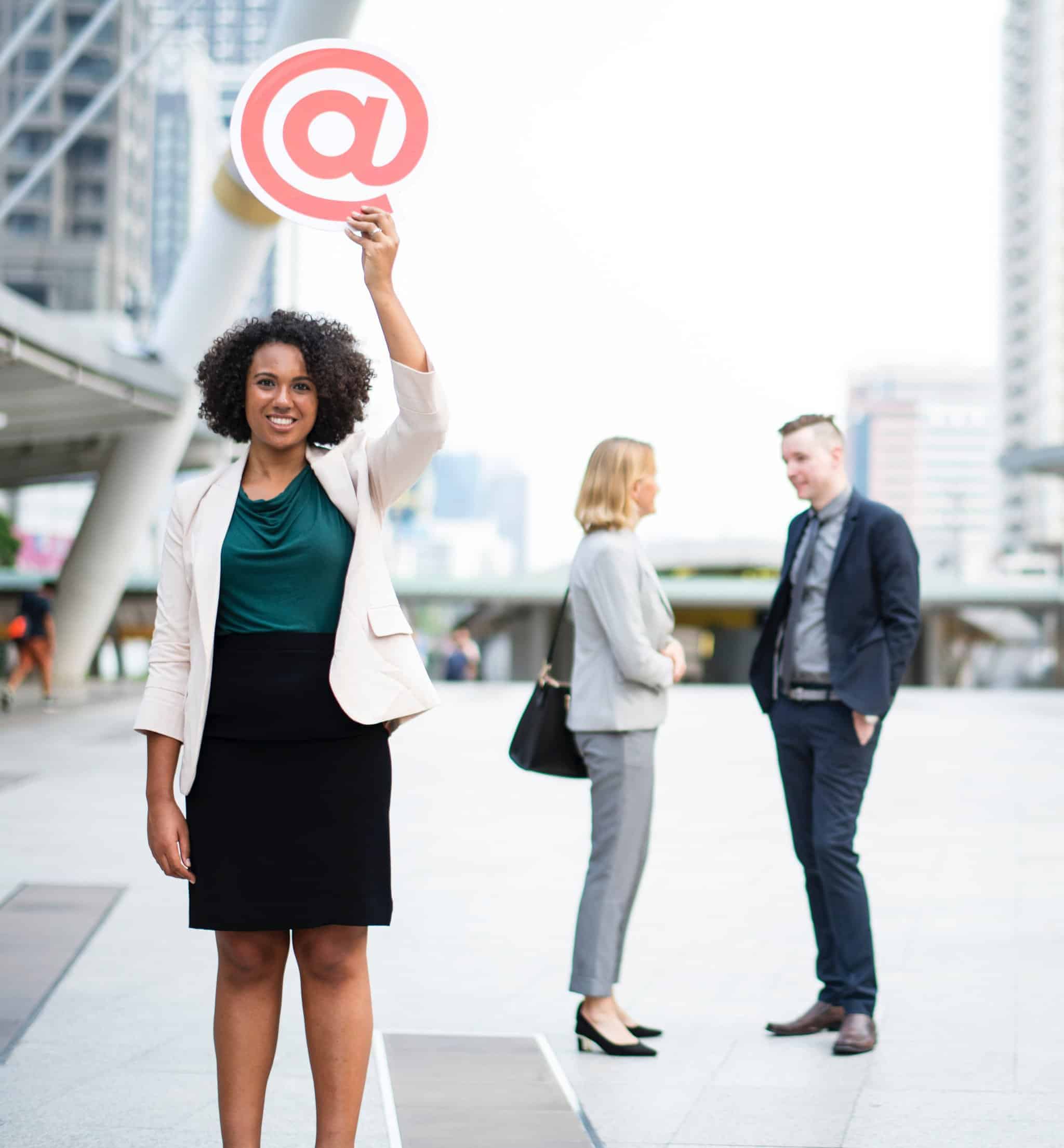 person smilingly shows the @ sign, symbol for an e-mail address