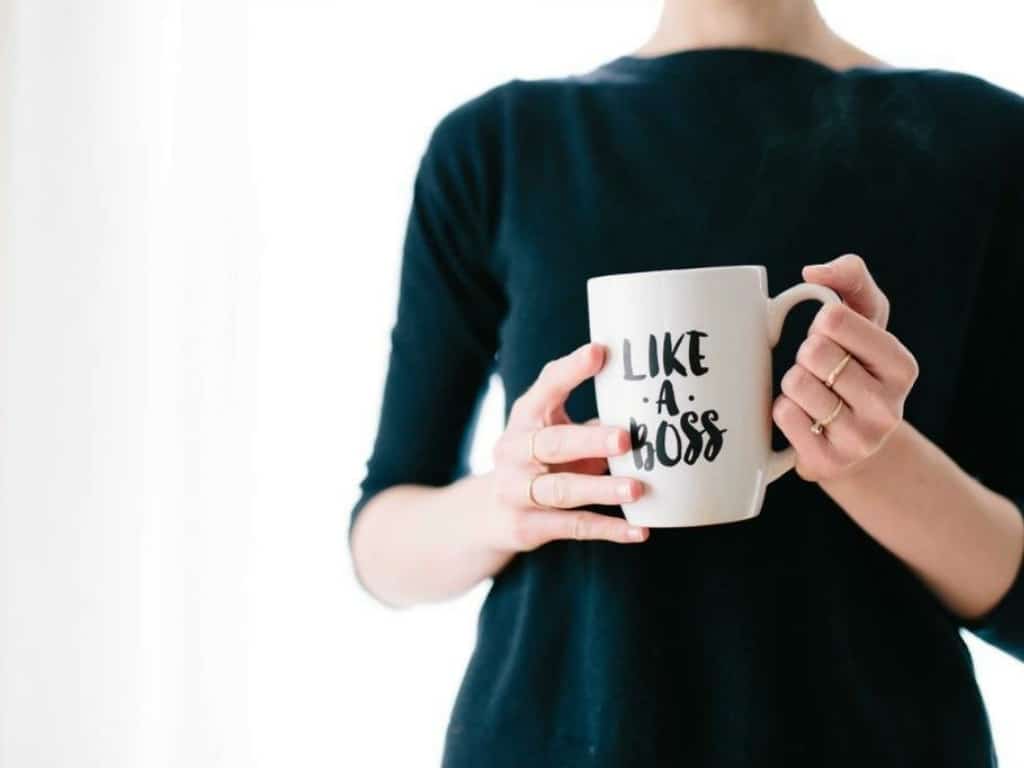 Frau mit einer Tasse mit Schriftzug "Like a boss"